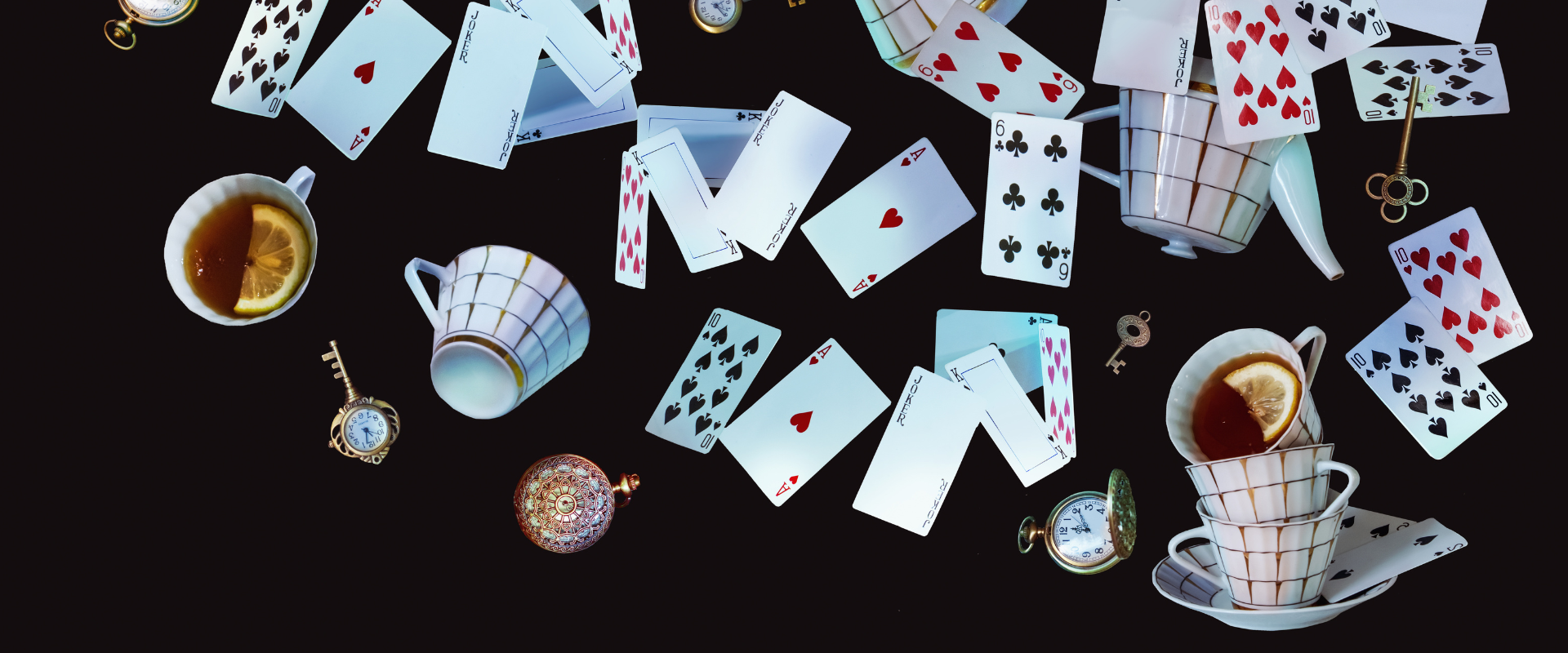 A bunch of playing cards , cups , and teapots on a black background.