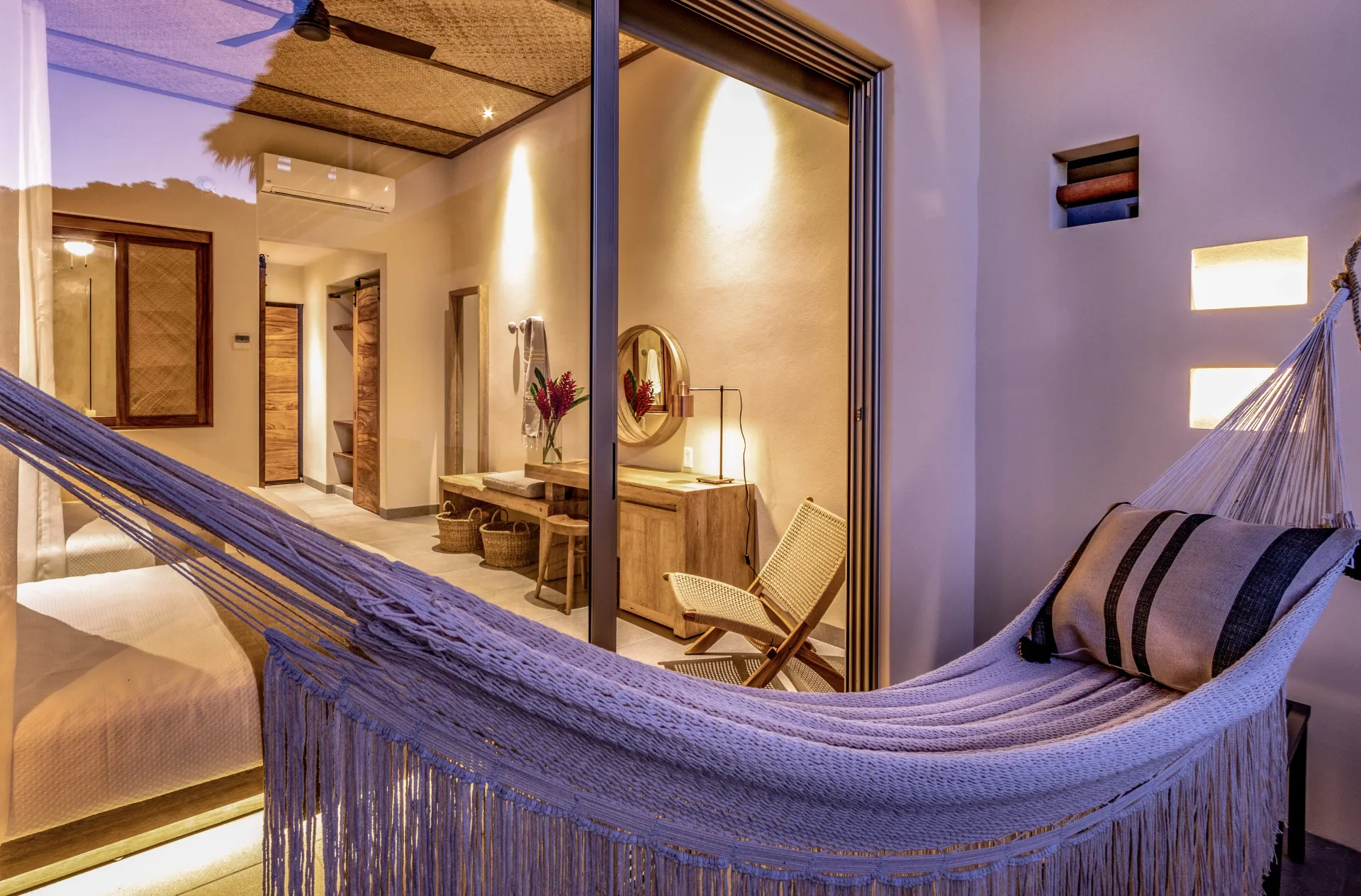 Hamaca en balcón con vistas a una habitación con escritorio, silla y elementos decorativos.