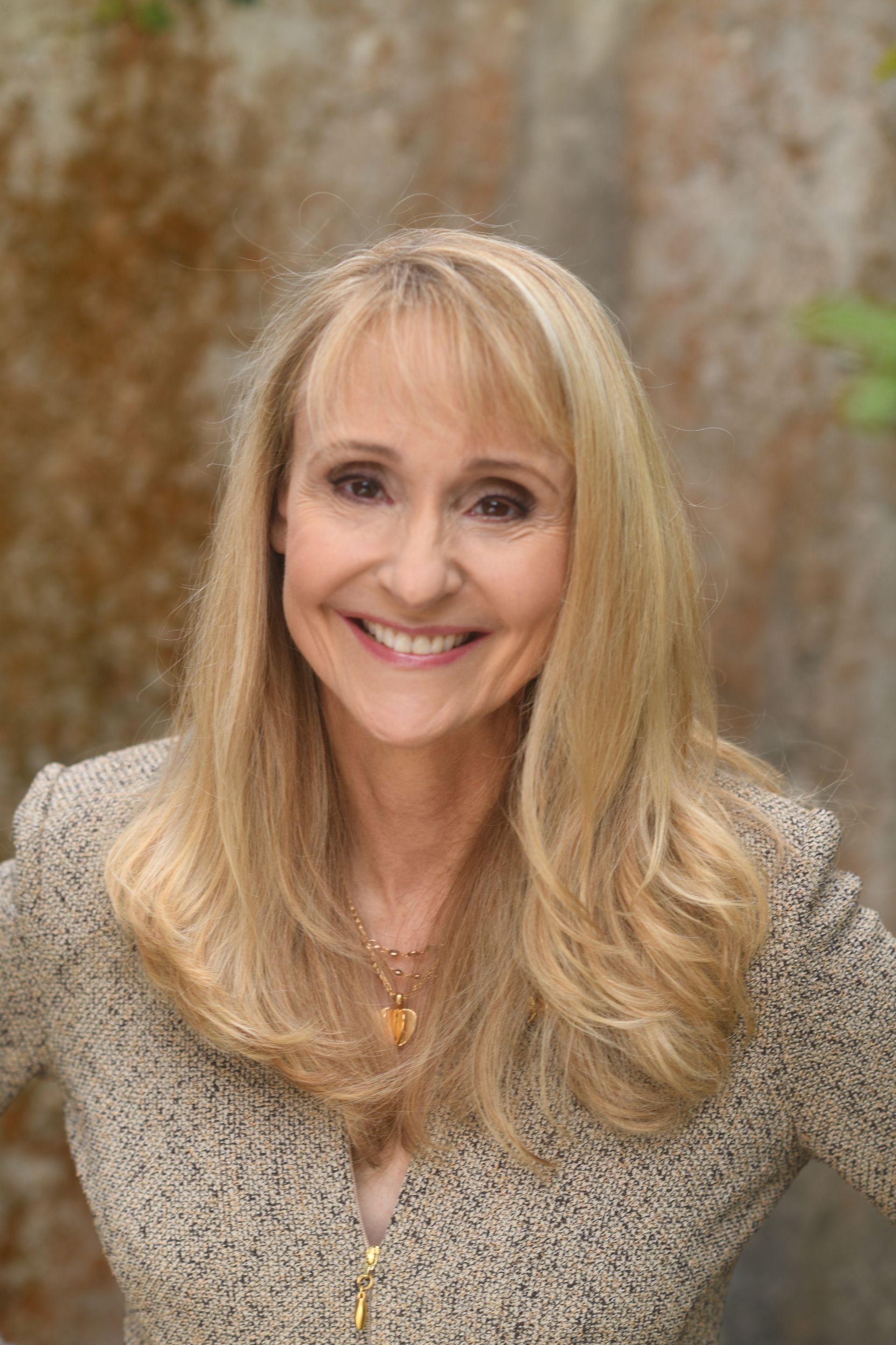 A woman with long blonde hair is smiling for the camera.