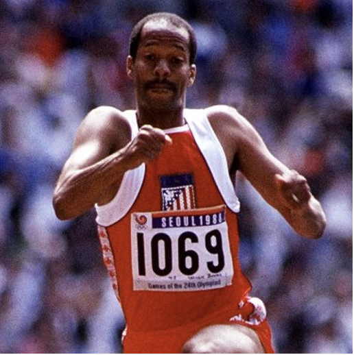 A woman in a suit and collared shirt is smiling for the camera.