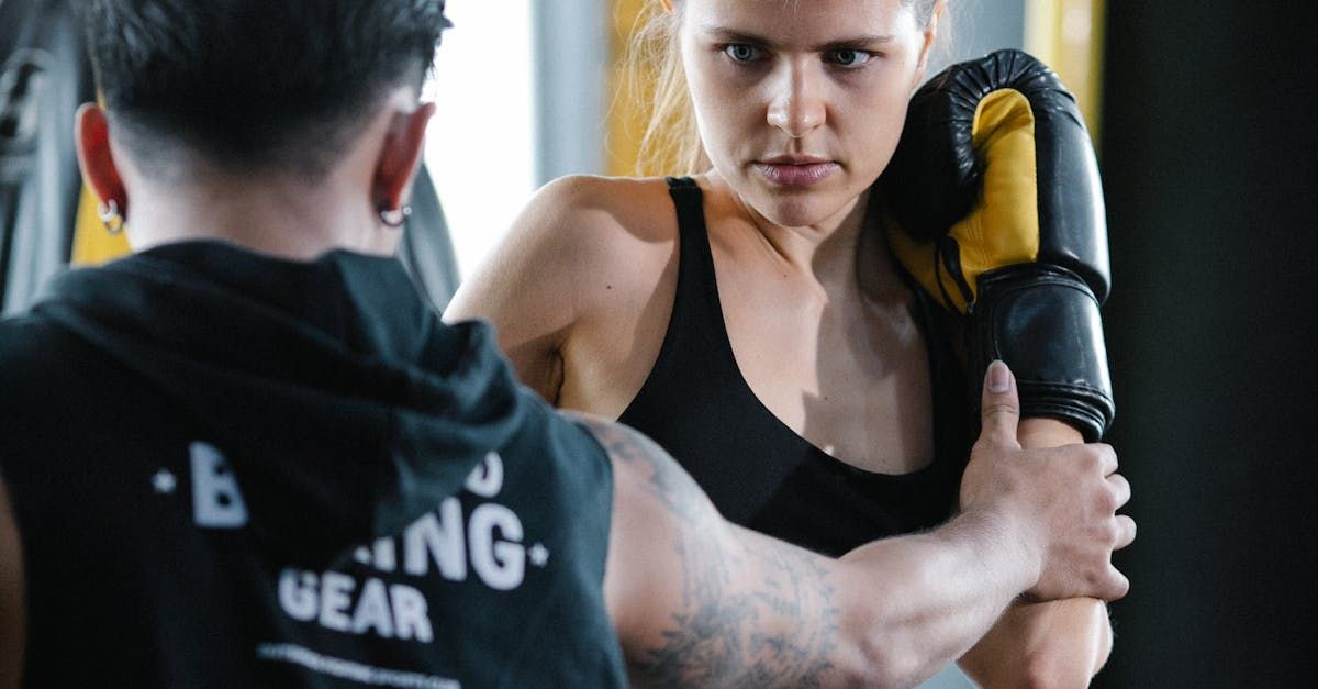 A man and a woman are boxing in a gym.