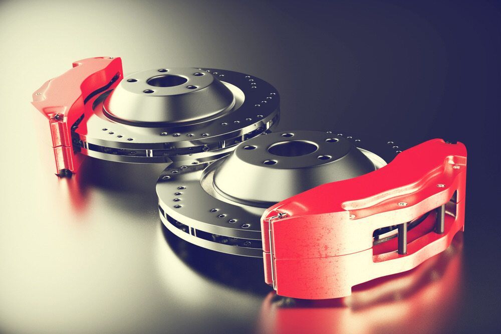 A Pair of Red Brake Pads and Rotors on a Table — M & D Shipp Smash Repairs In Dubbo, NSW