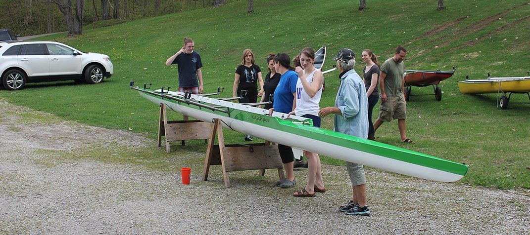 Rowing Team Standing Next to Boat