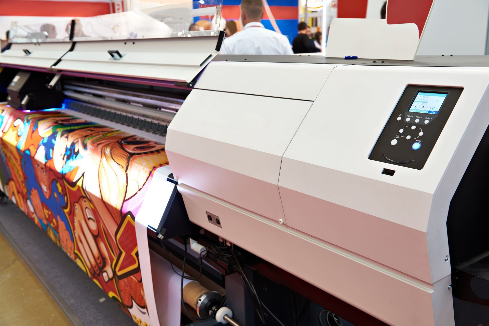 Large-format printer printing a colorful banner in a print shop