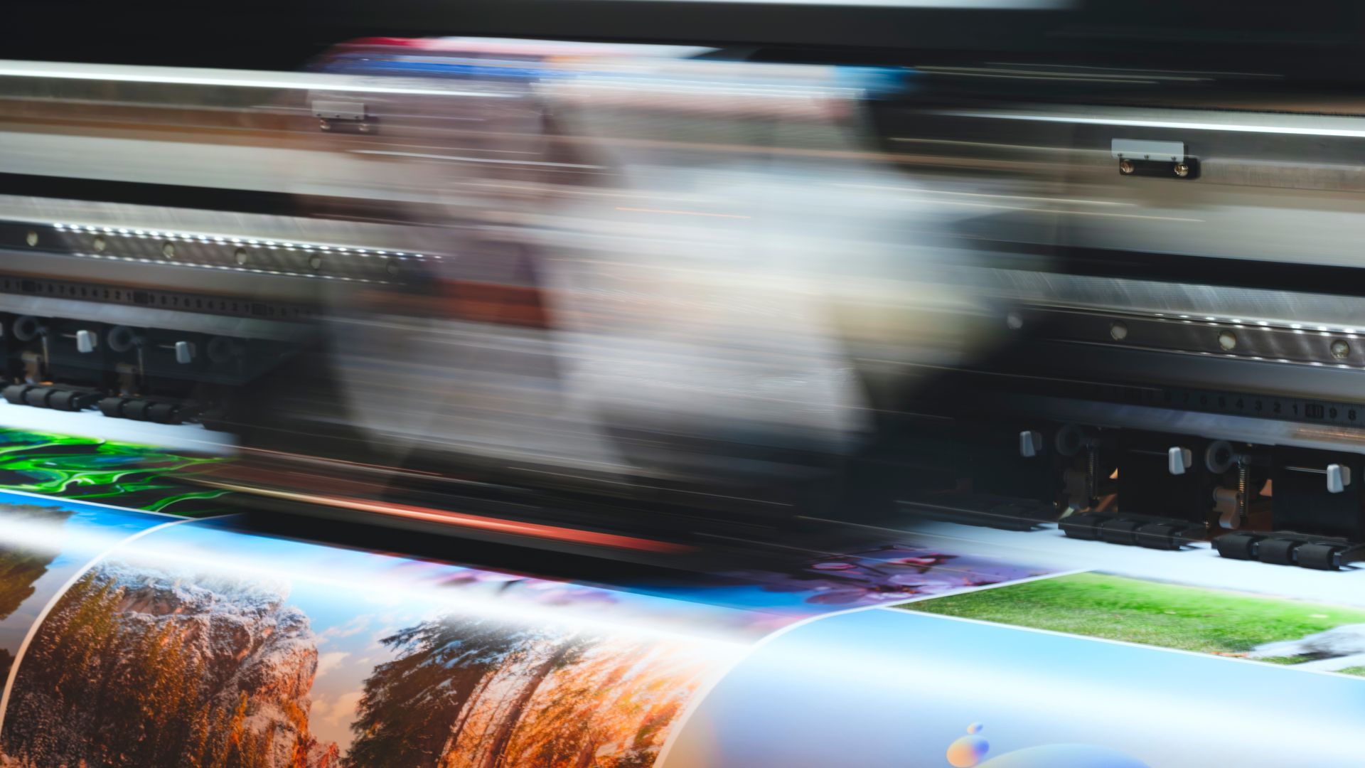Large-format printer in motion printing a colorful landscape poster