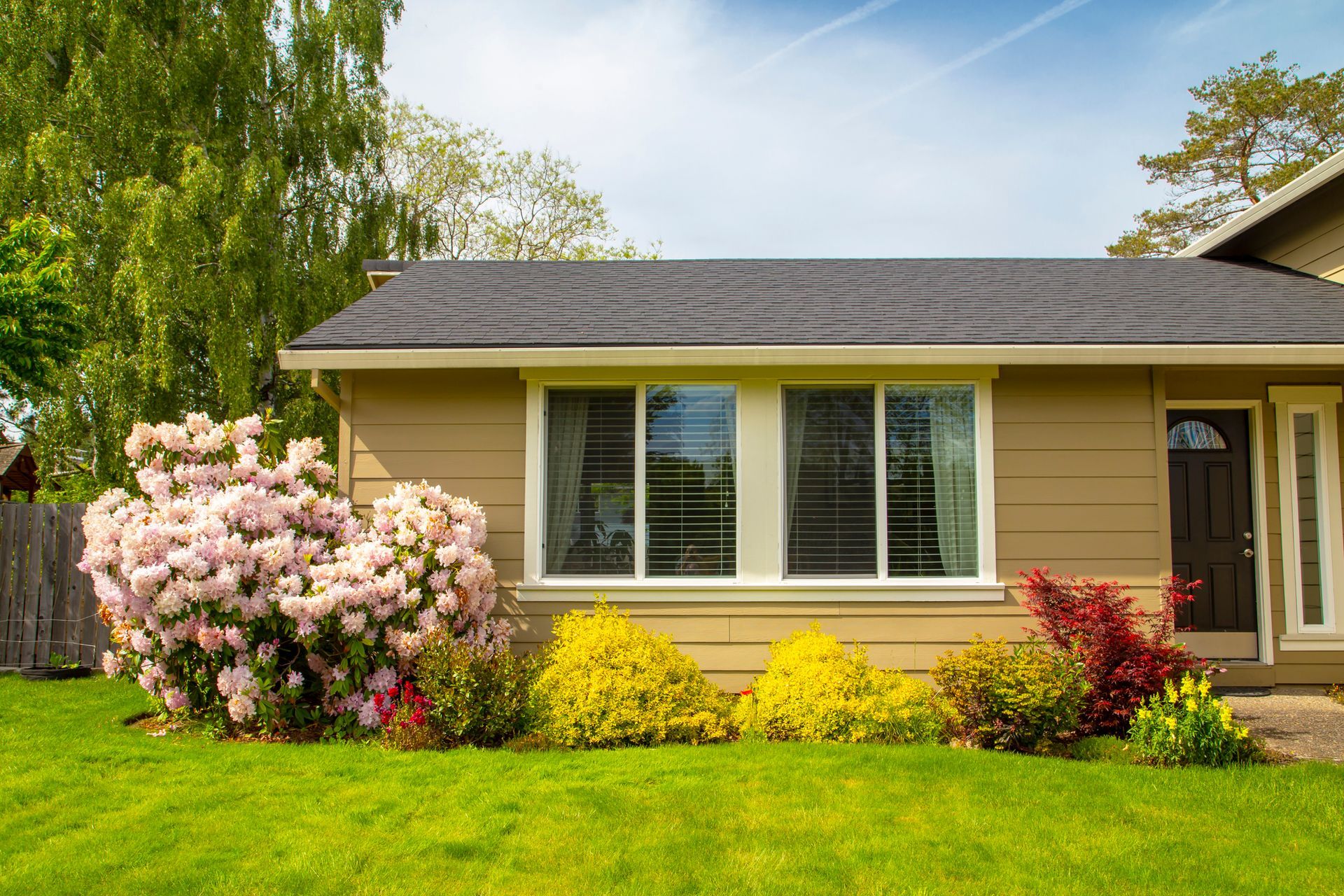 A Small House With A Lush Green Lawn And Flowers In Front Of It | Jefferson, NC | Sheets Brothers, Inc.