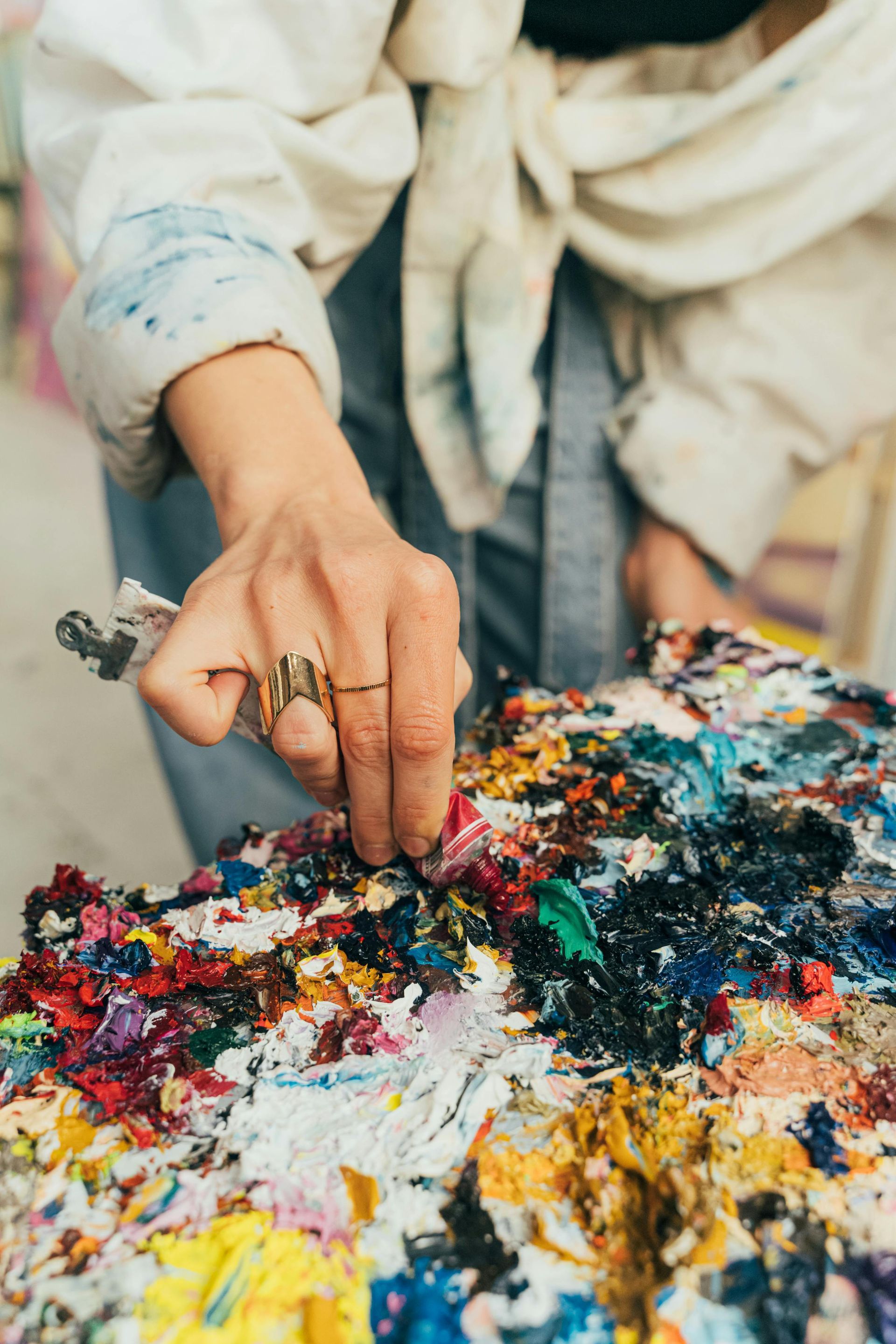 A woman is painting on a palette with a brush.