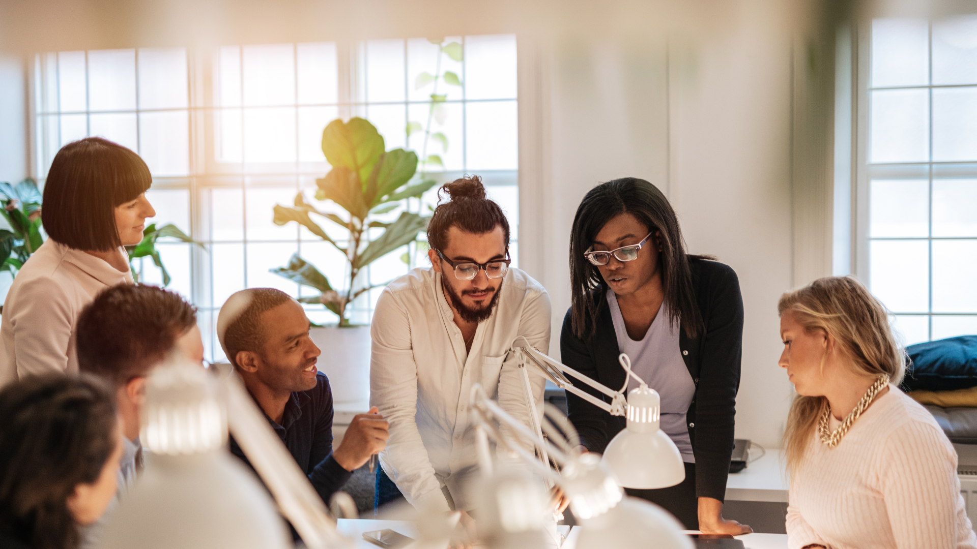 Group of diverse professionals collaborating around a table in a bright office.