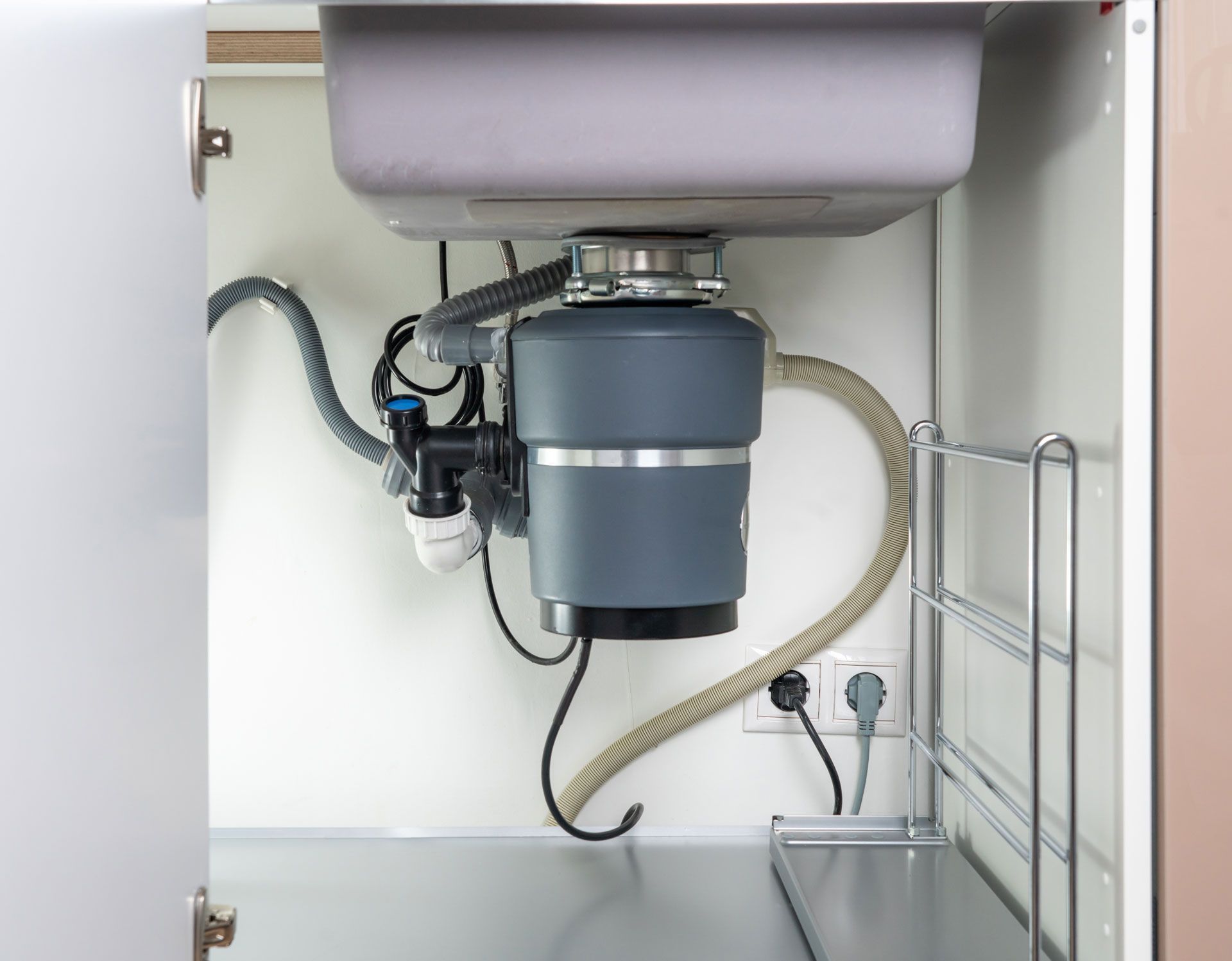 A kitchen sink with a garbage disposal underneath it.