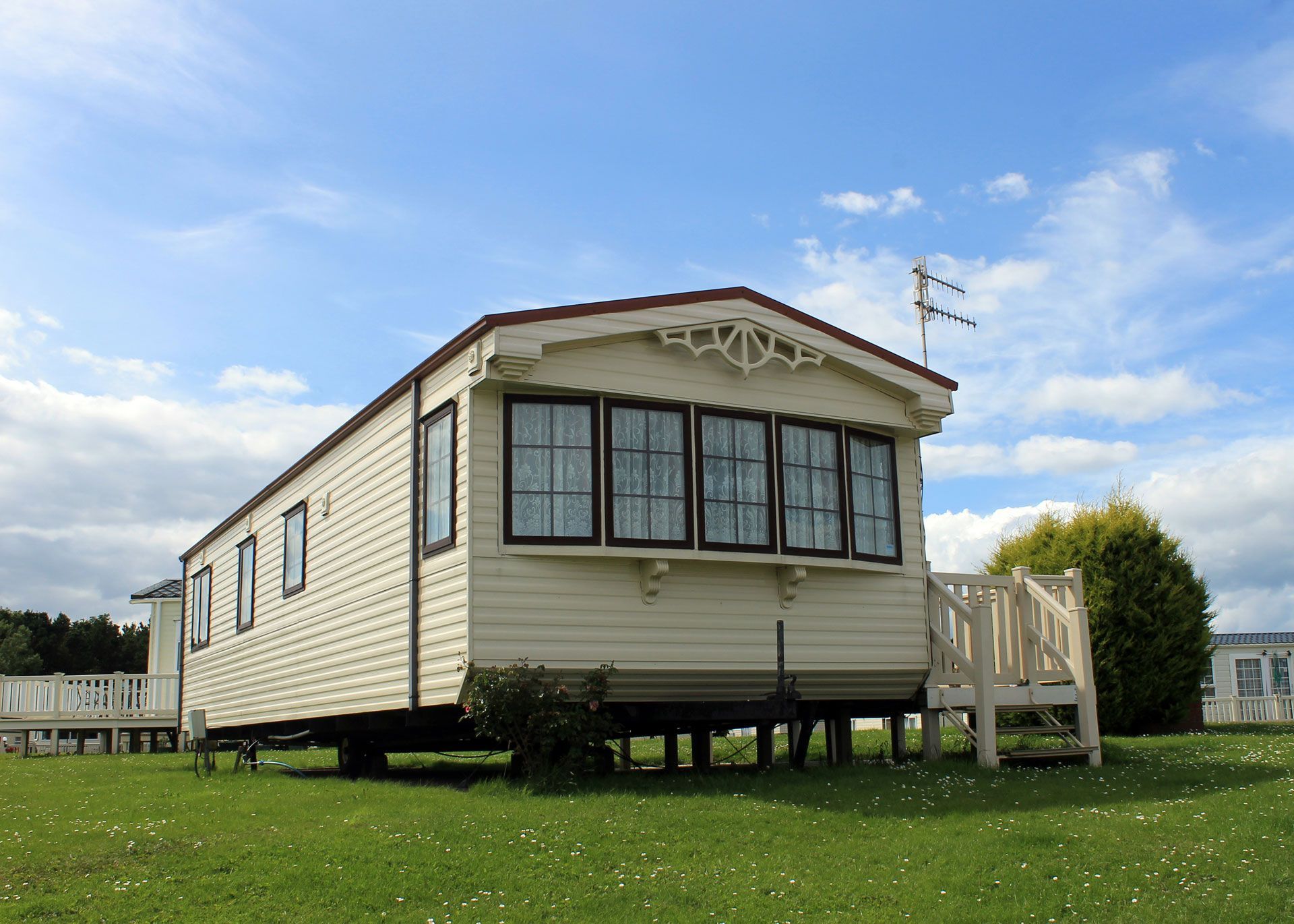 A mobile home is parked in the middle of a grassy field.