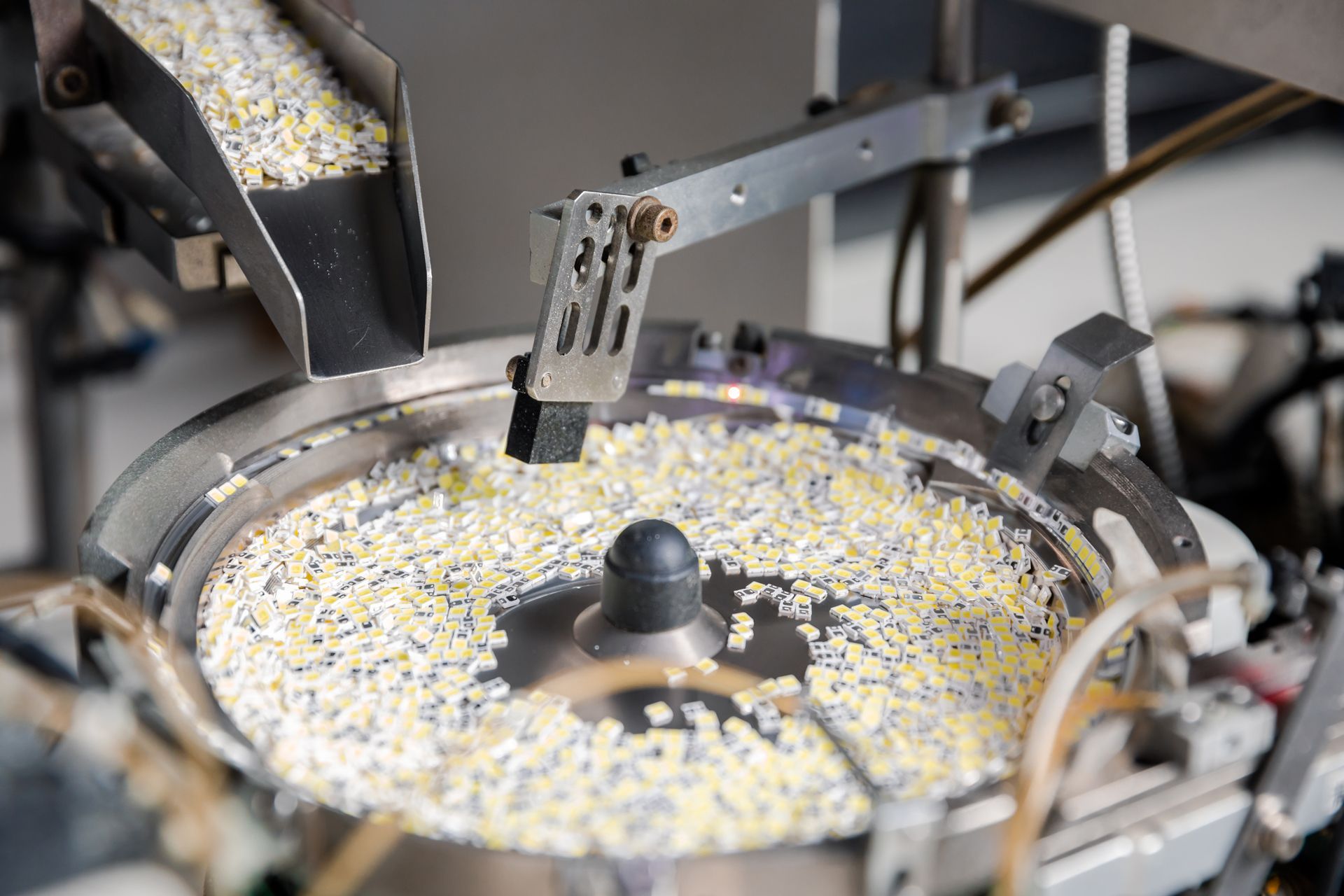 Eine helle, weisse Neonröhre beleuchtet eine strukturierte, dunkelgraue Wand mit einem rechteckigen Lichtstrahl.