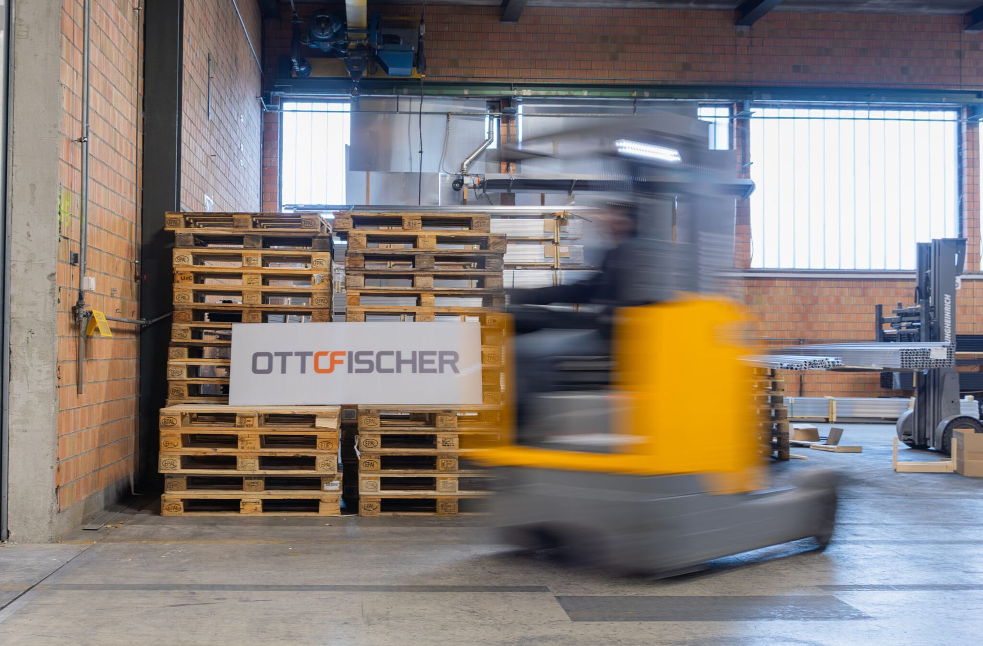 Ein grosses Büro mit vielen Fenstern und einem Schreibtisch mit einem Computer darauf.