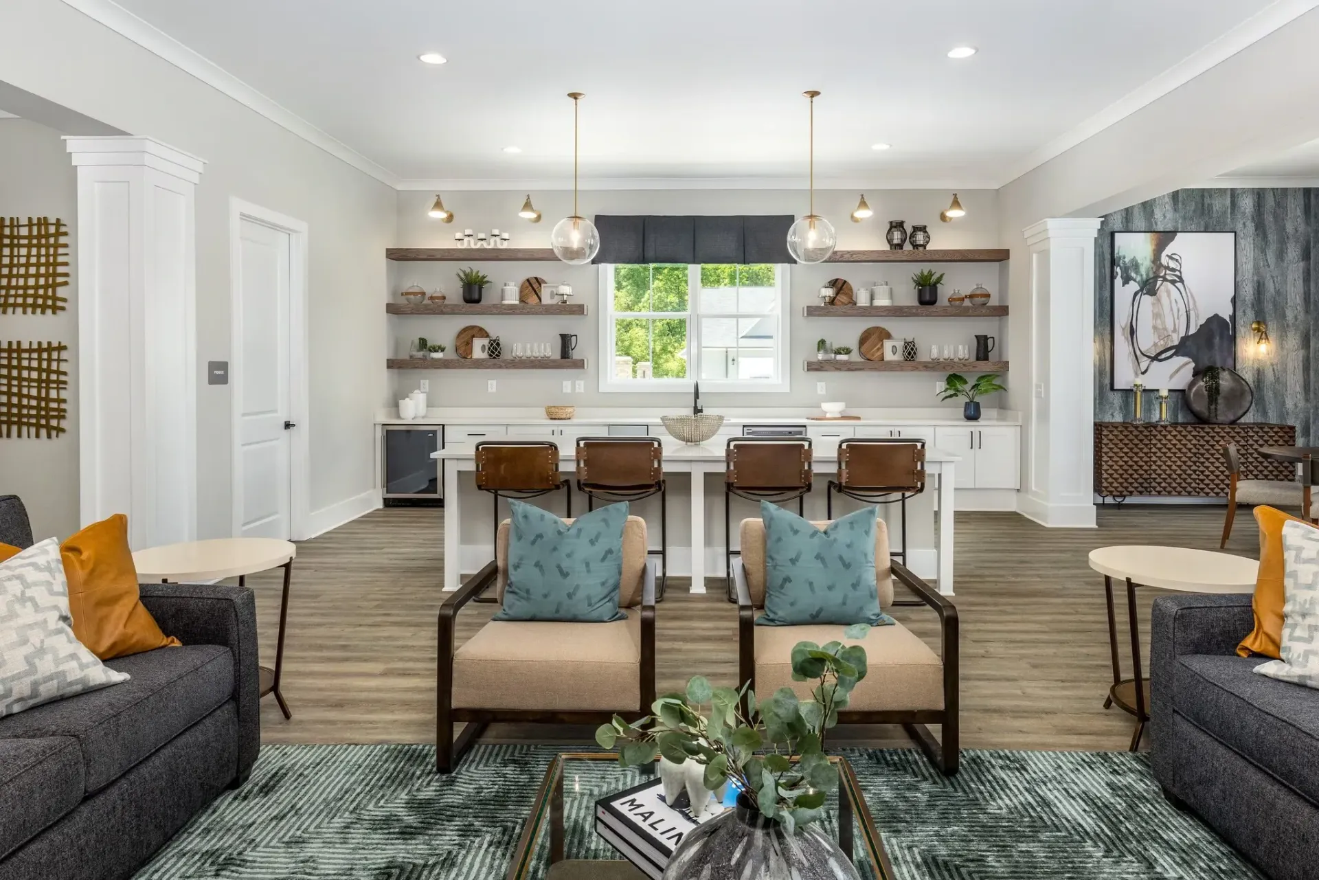 Modern common area with a full-service bar, lounge seating, and decorative shelving.