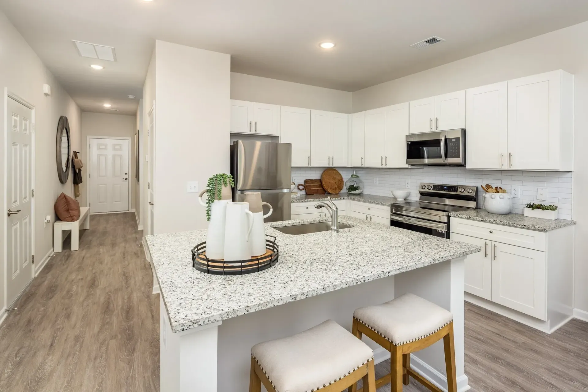 Modern kitchen with granite countertops, stainless steel appliances, and a breakfast bar.