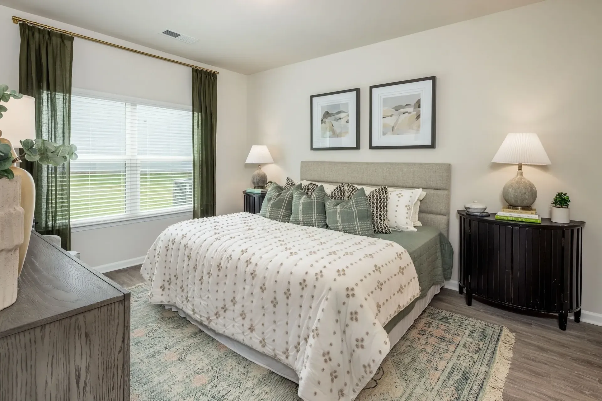 Bedroom with a large bed, dresser, nightstand, and window with blinds.