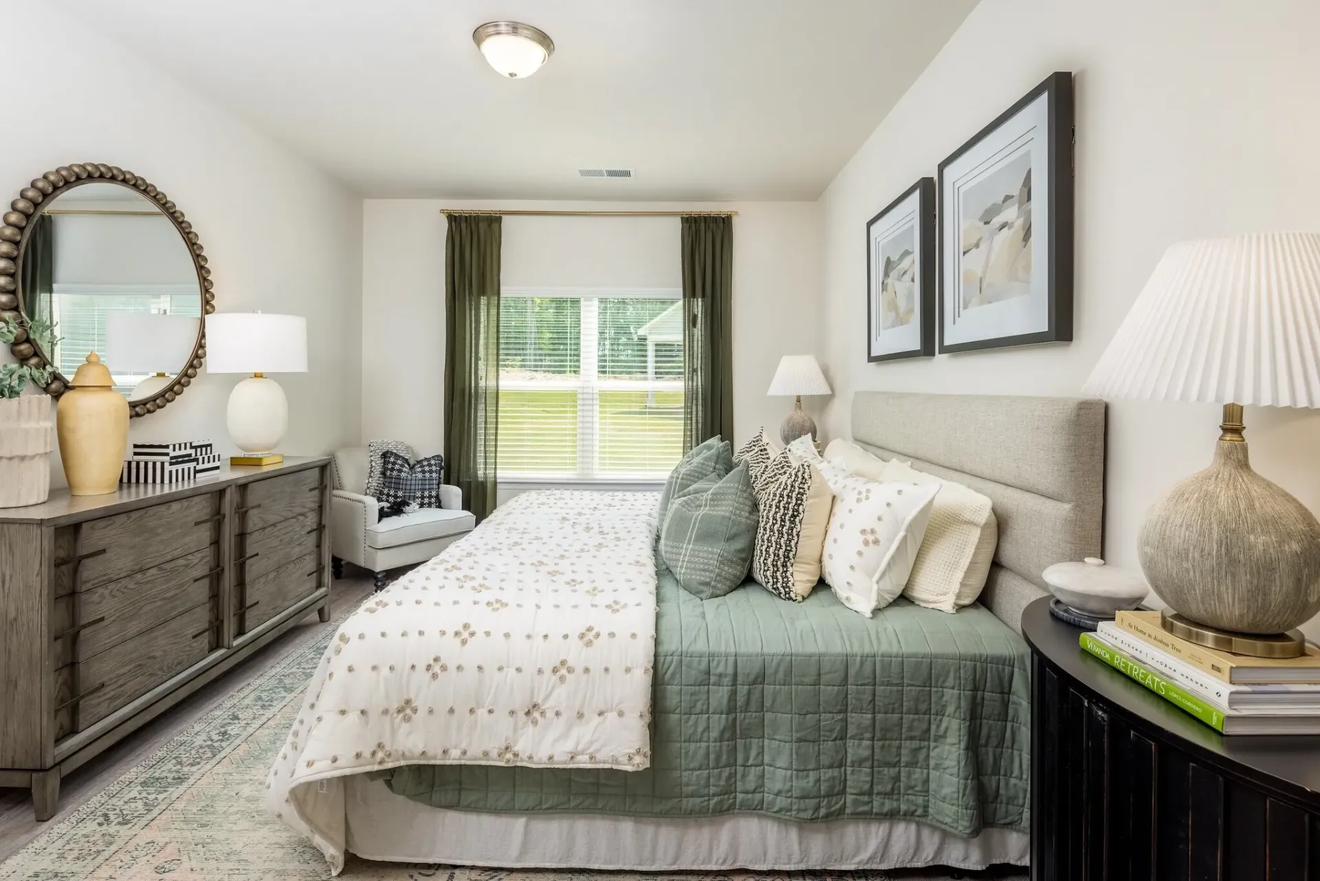 Bedroom with king-size bed, dresser, mirror, and armchair.
