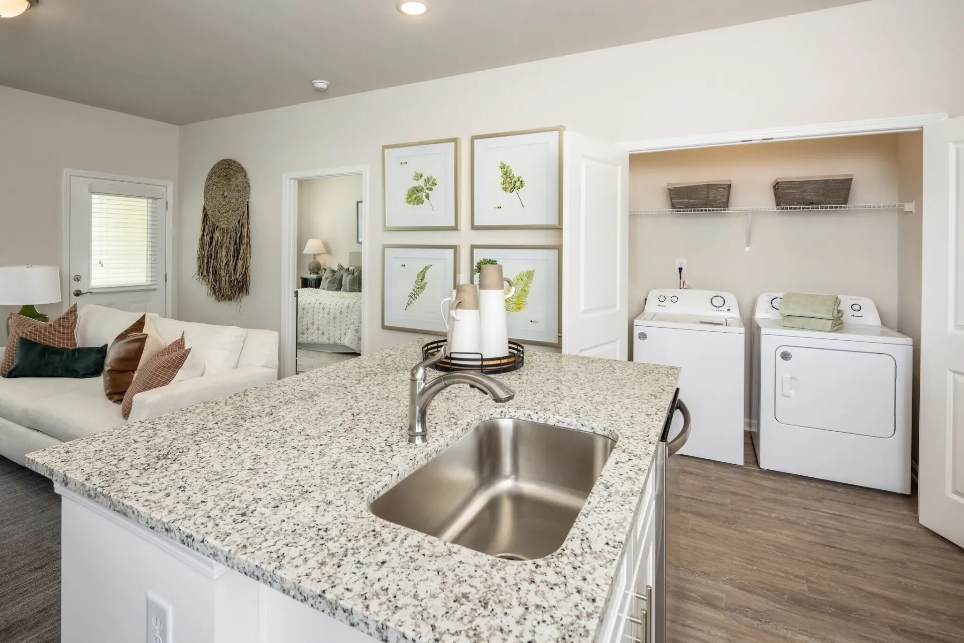 Kitchen island with sink, living room, and laundry area with washer and dryer.