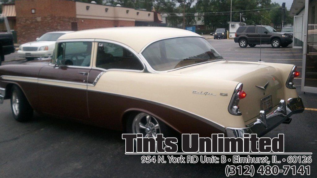 A brown and white car with tints unlimited written on it