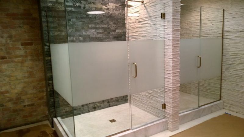 A bathroom with a walk in shower and a brick wall.