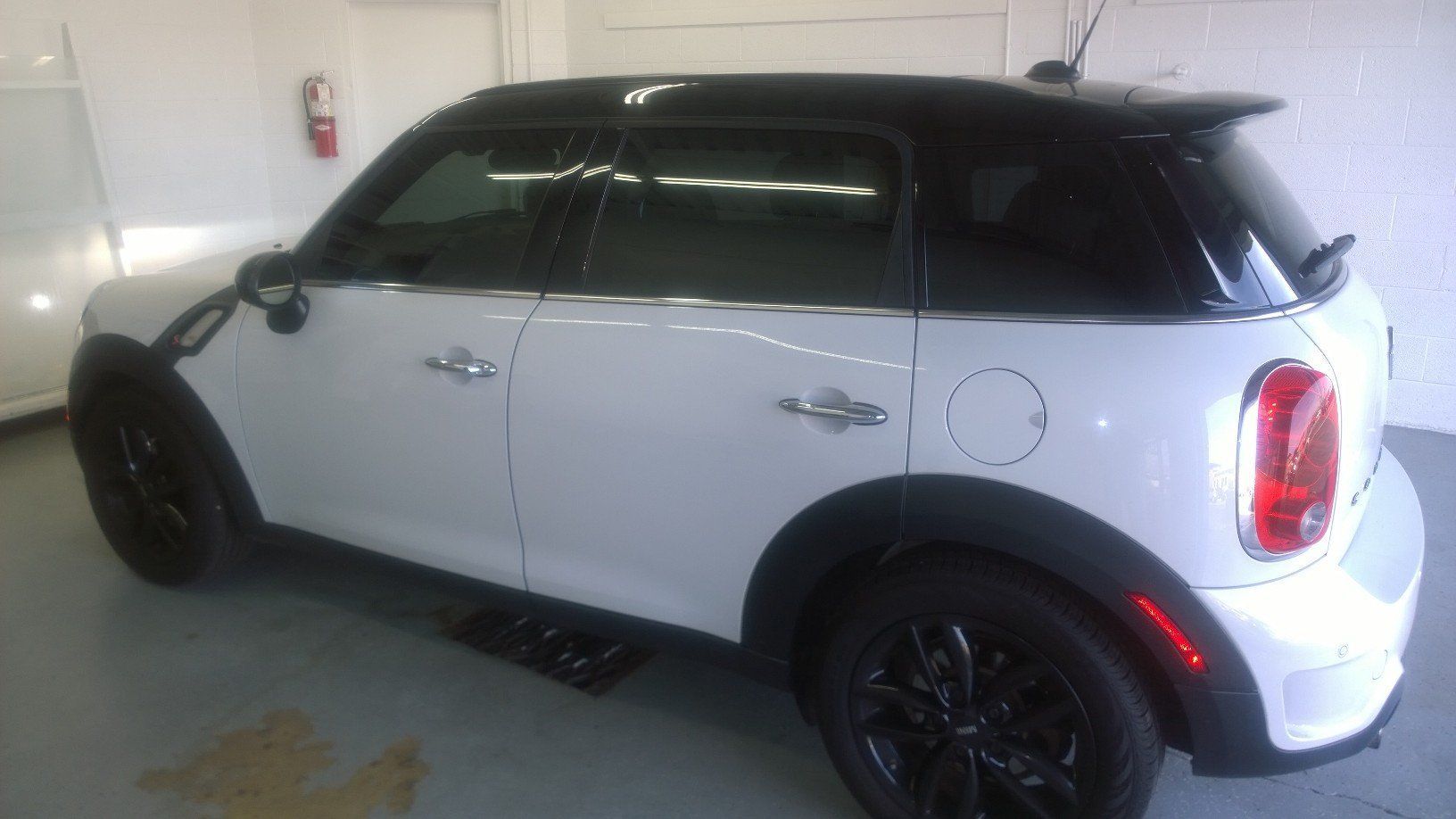 A white mini cooper is parked in a garage.
