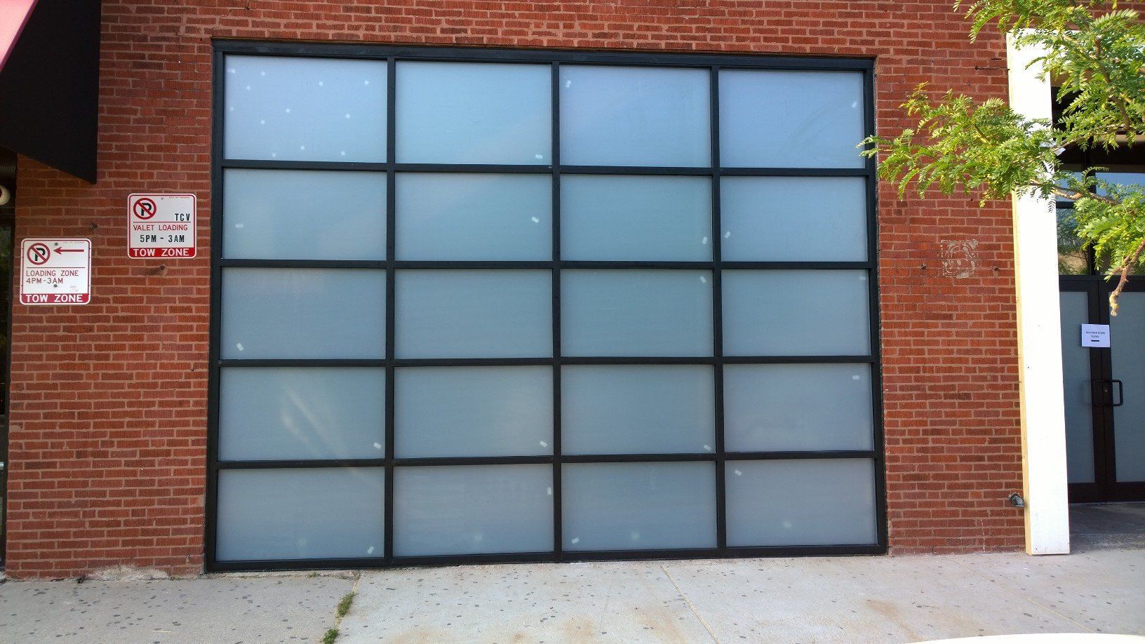 A brick building with a large glass door