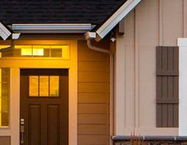 The front door of a house is lit up at night.