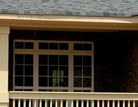 A balcony with a railing and a lot of windows on a house.