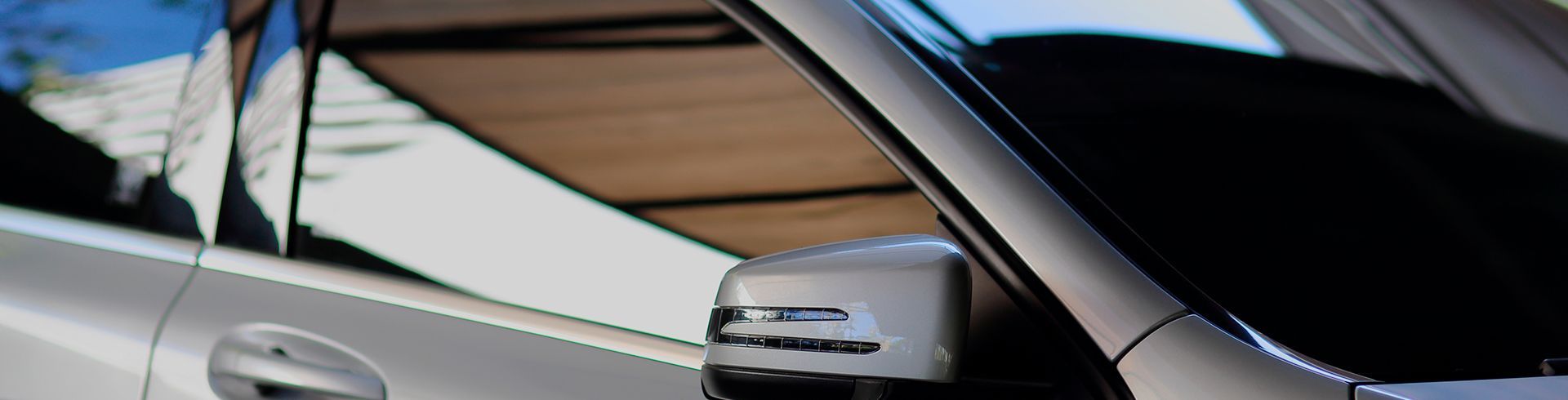 A close up of a car 's side mirror and windshield.