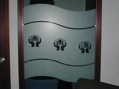 A door with three hands holding a globe on it