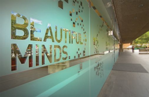 A glass wall with the words `` beautiful minds '' written on it.