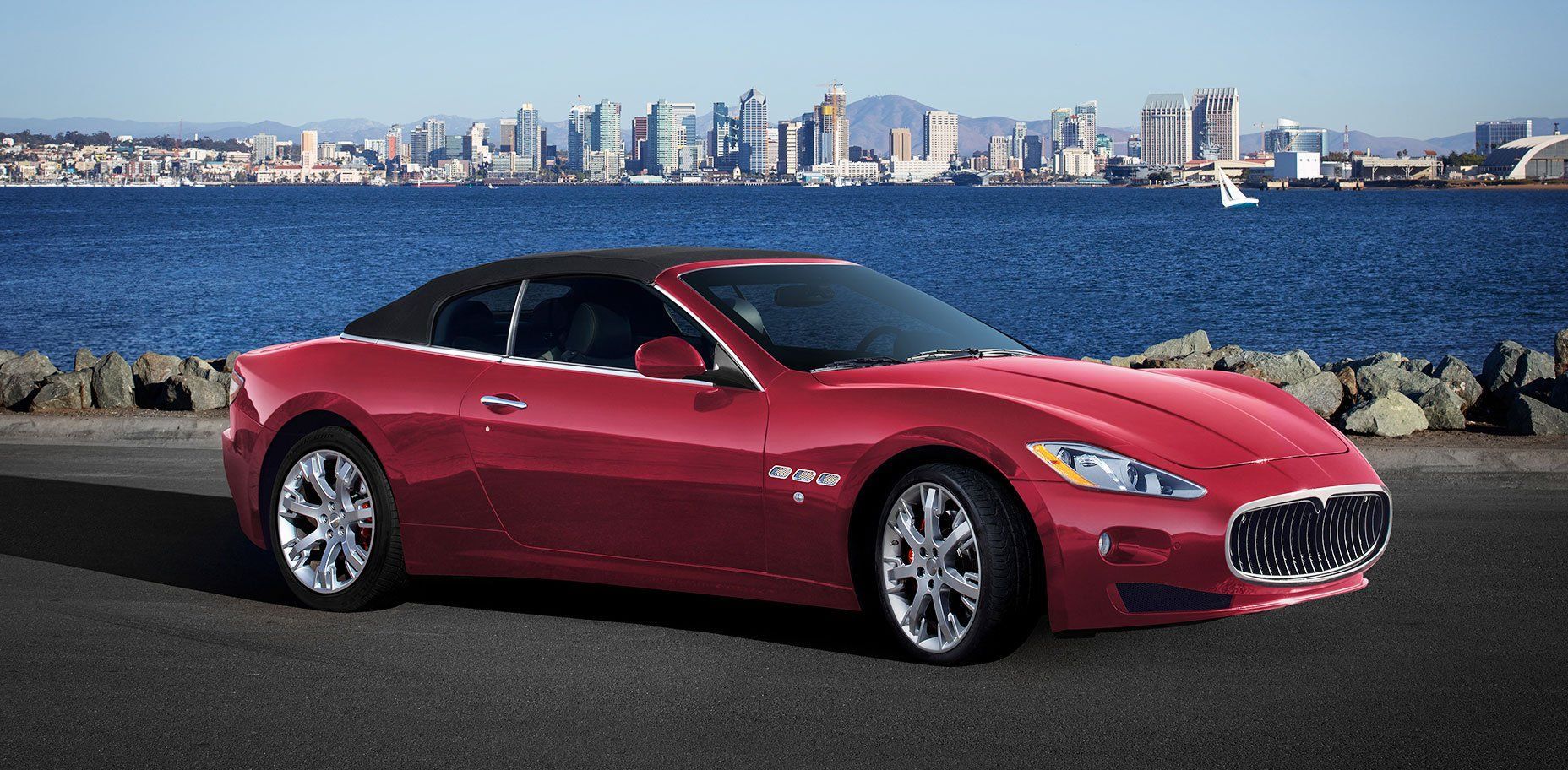 A red convertible car is parked on the side of the road