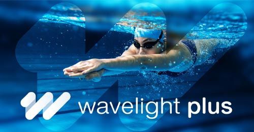 A swimmer dives beneath the surface of the water. A logo on top of the image says: wavelight plus
