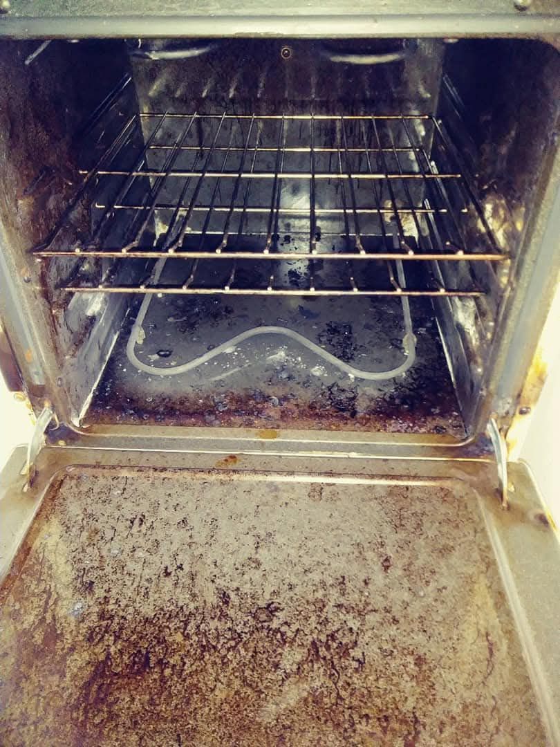 The inside of a dirty oven with the door open.