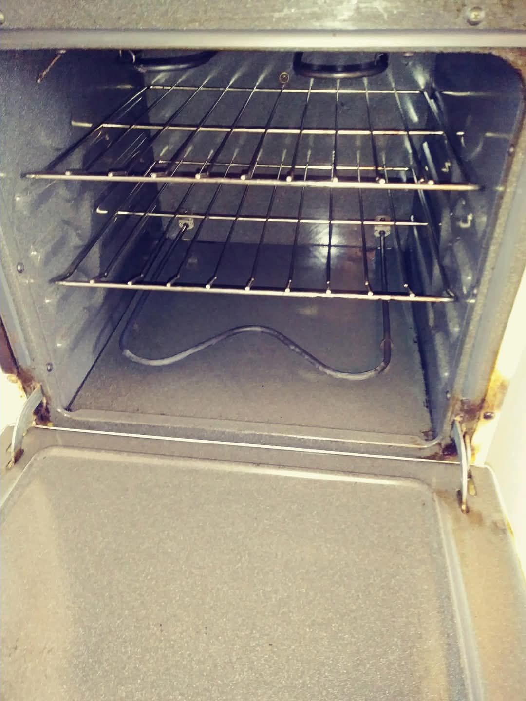The inside of an oven with the door open and the racks empty.