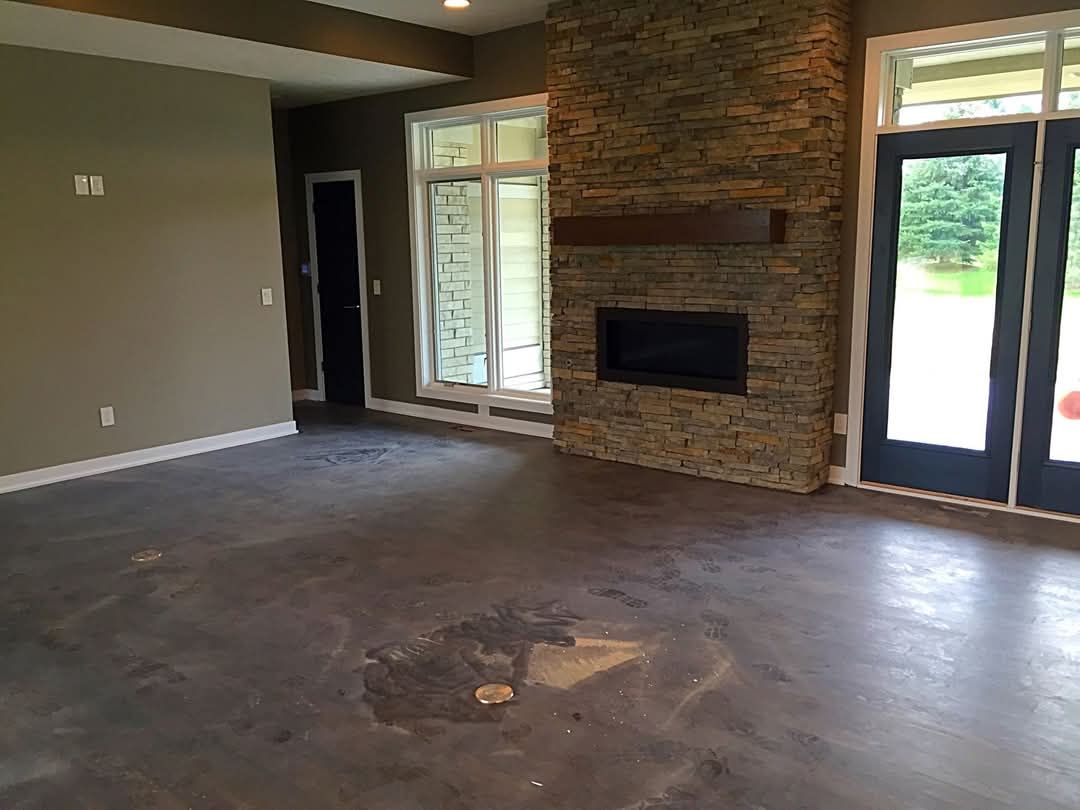 An empty living room with a fireplace and sliding glass doors.
