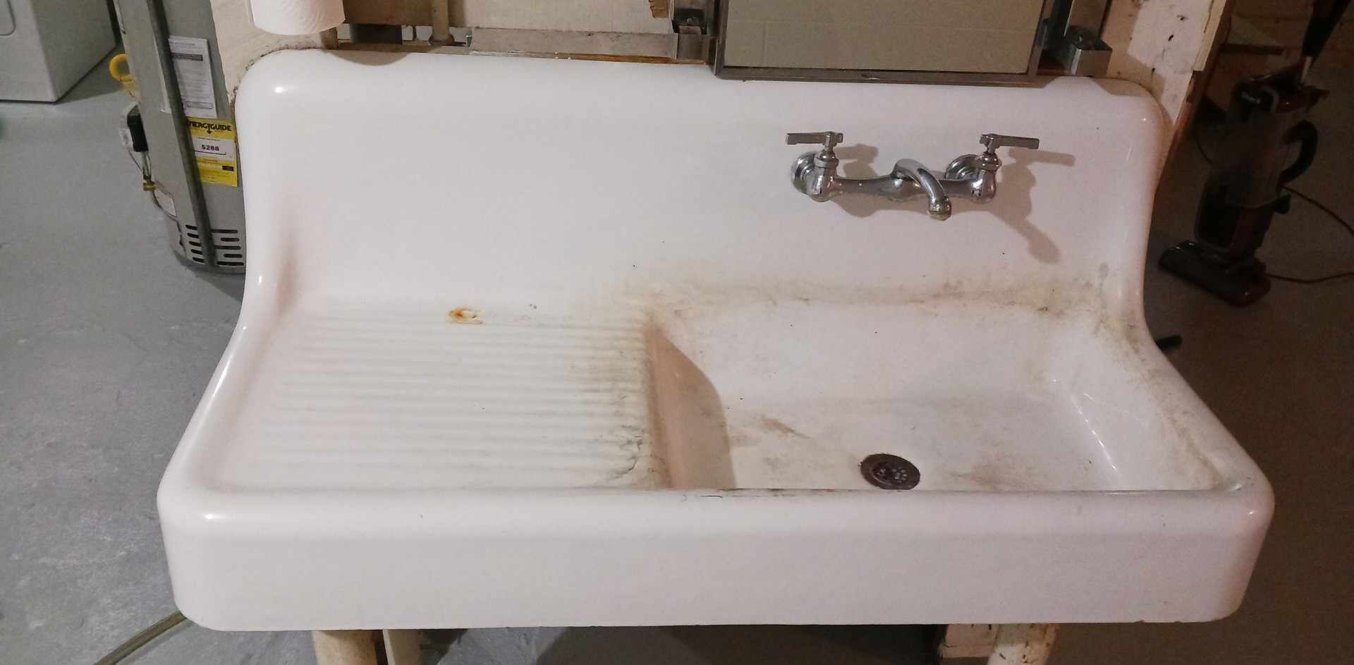 A white sink is sitting on a wooden table in a room.