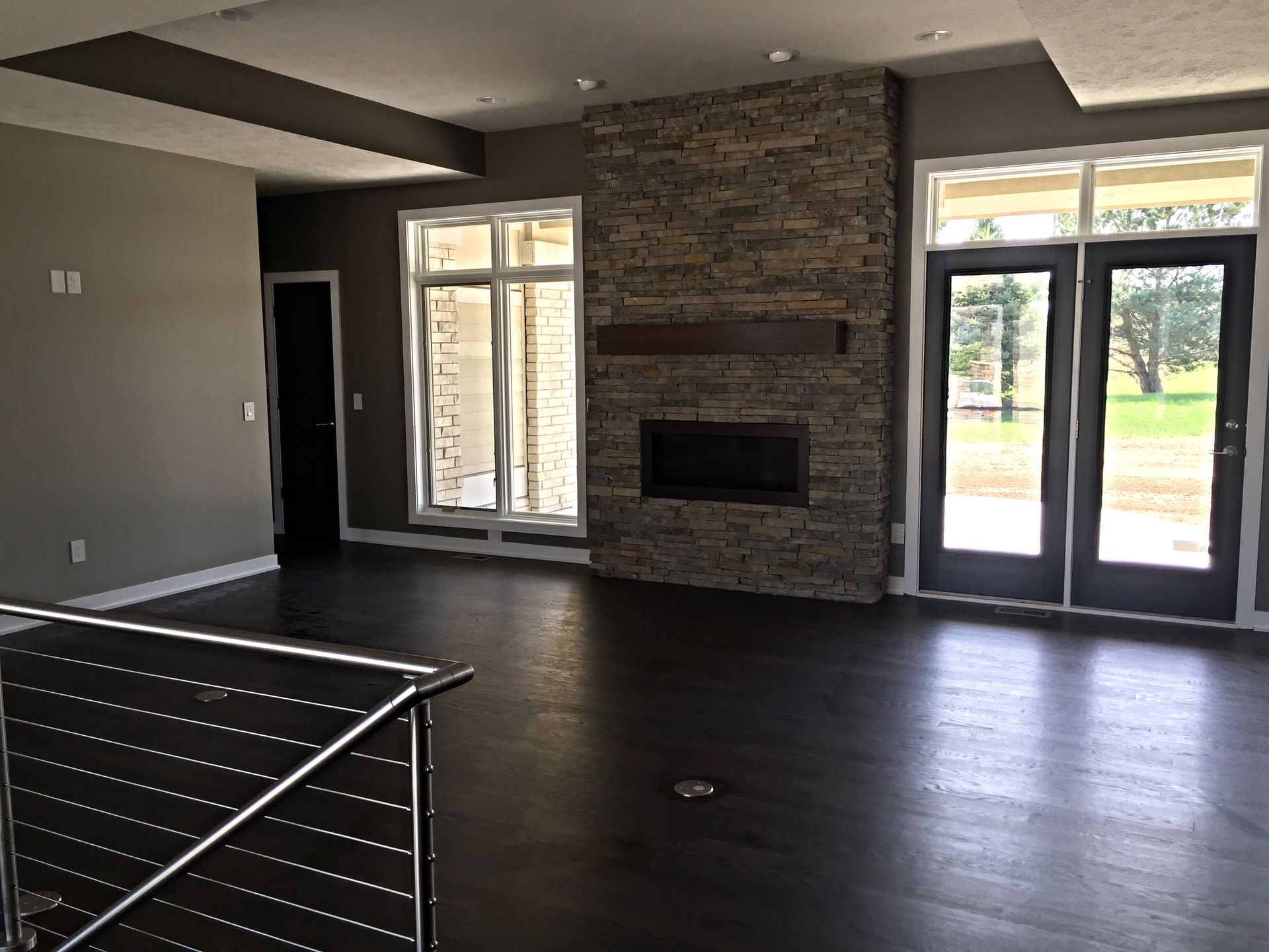 An empty living room with a fireplace and stairs
