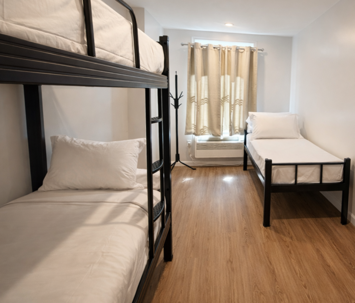 A minimalist bedroom with a metal bunk bed on the left, a single bed on the right, and light beige curtains by a window.