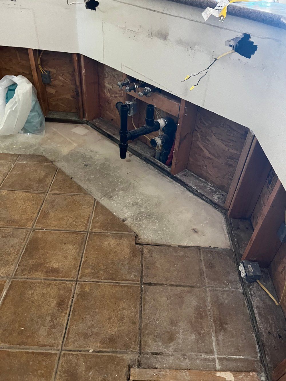 A bathroom with tile floors and a sink under a counter.