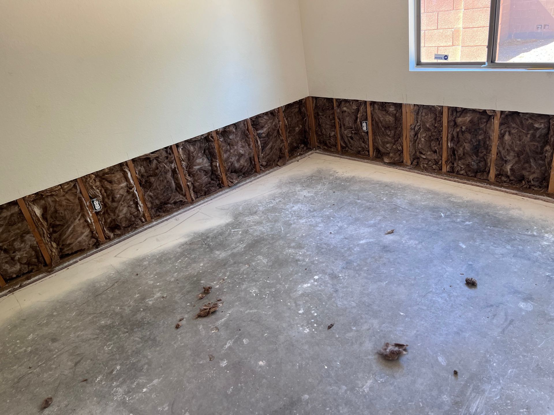 An empty room with a concrete floor and a window.