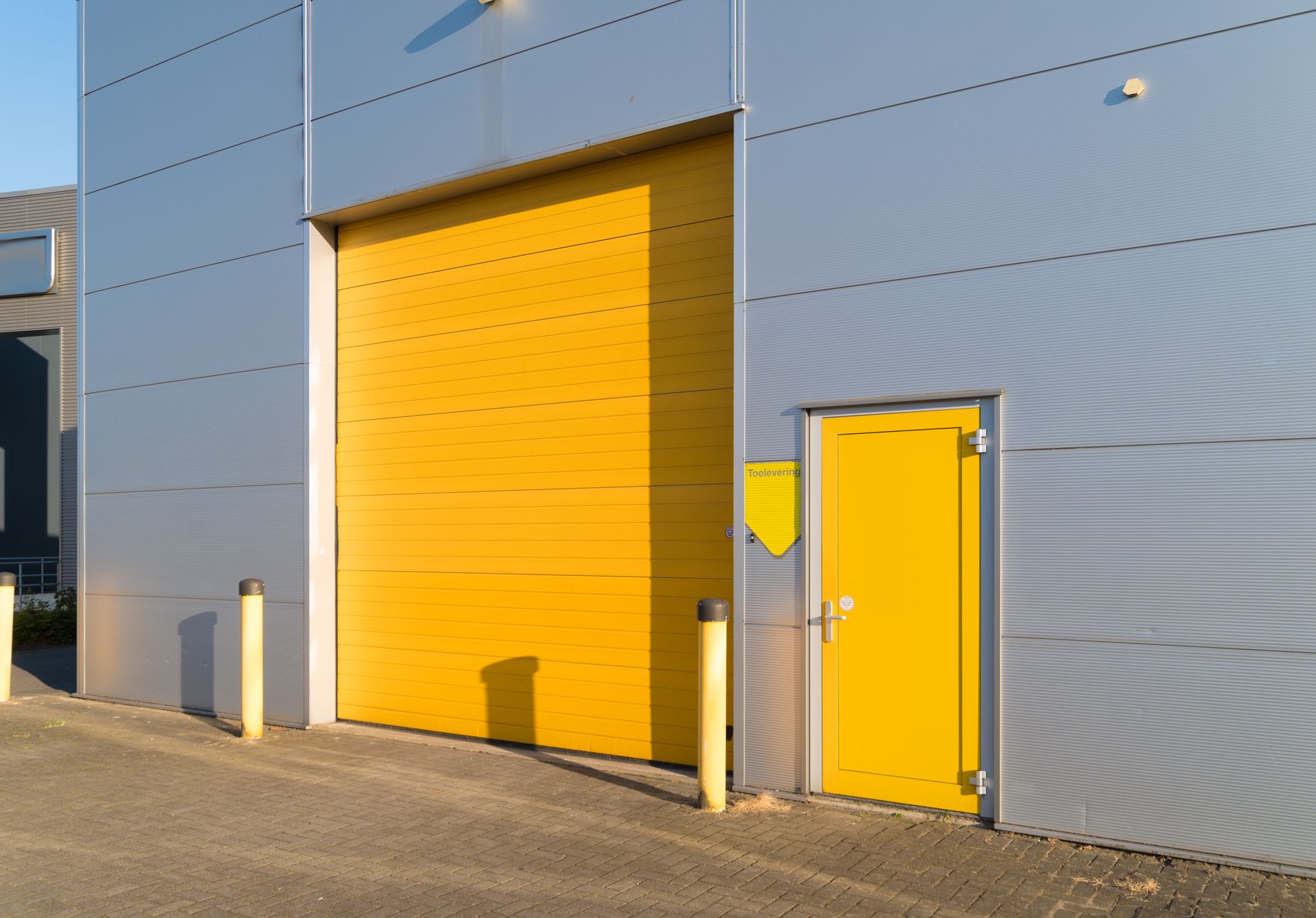 A yellow door is on the side of a building