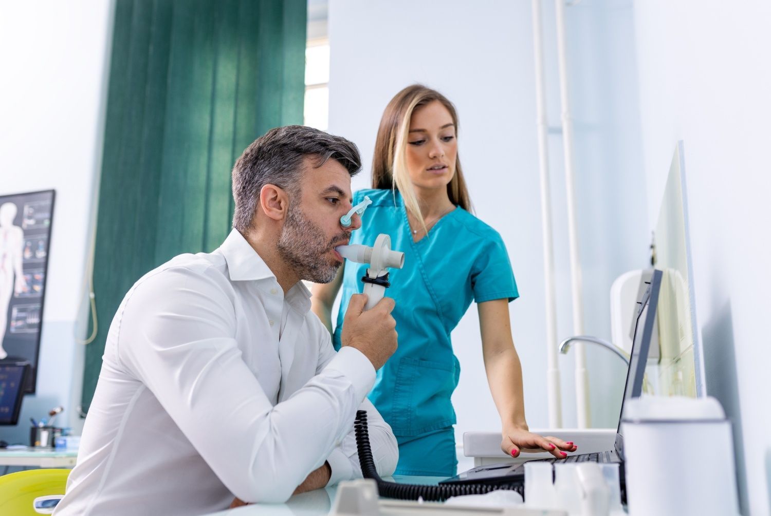 Man undergoing lung function test with a medical professional in a clinic.