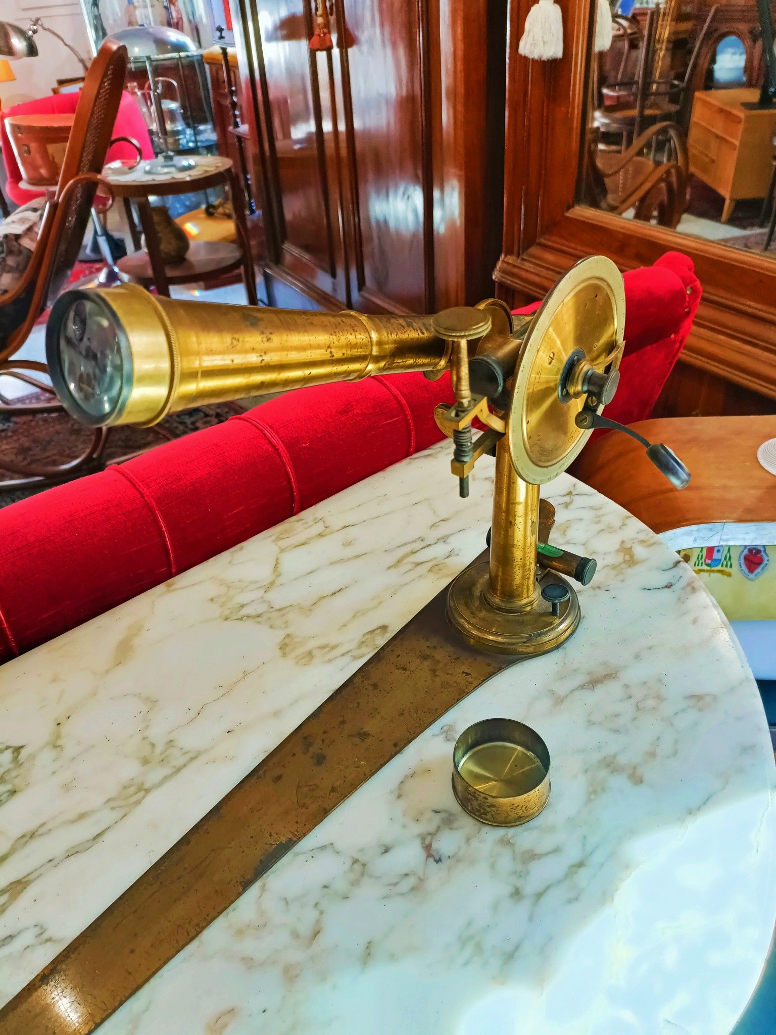 Un telescopio di ottone è appoggiato su un tavolo di marmo.