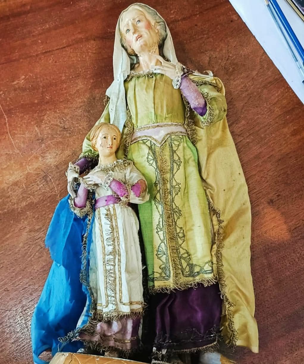 Un quadro incorniciato con fiori e una croce sopra