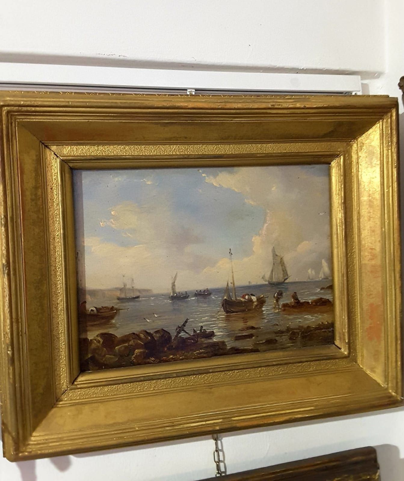 Un dipinto di barche nell'oceano in una cornice dorata