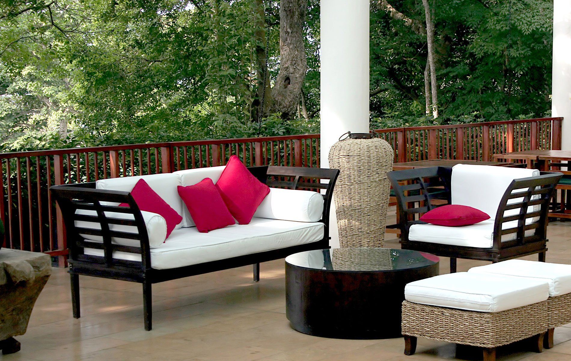 una terrazza con dei divani di legno e un tavolino rotondo