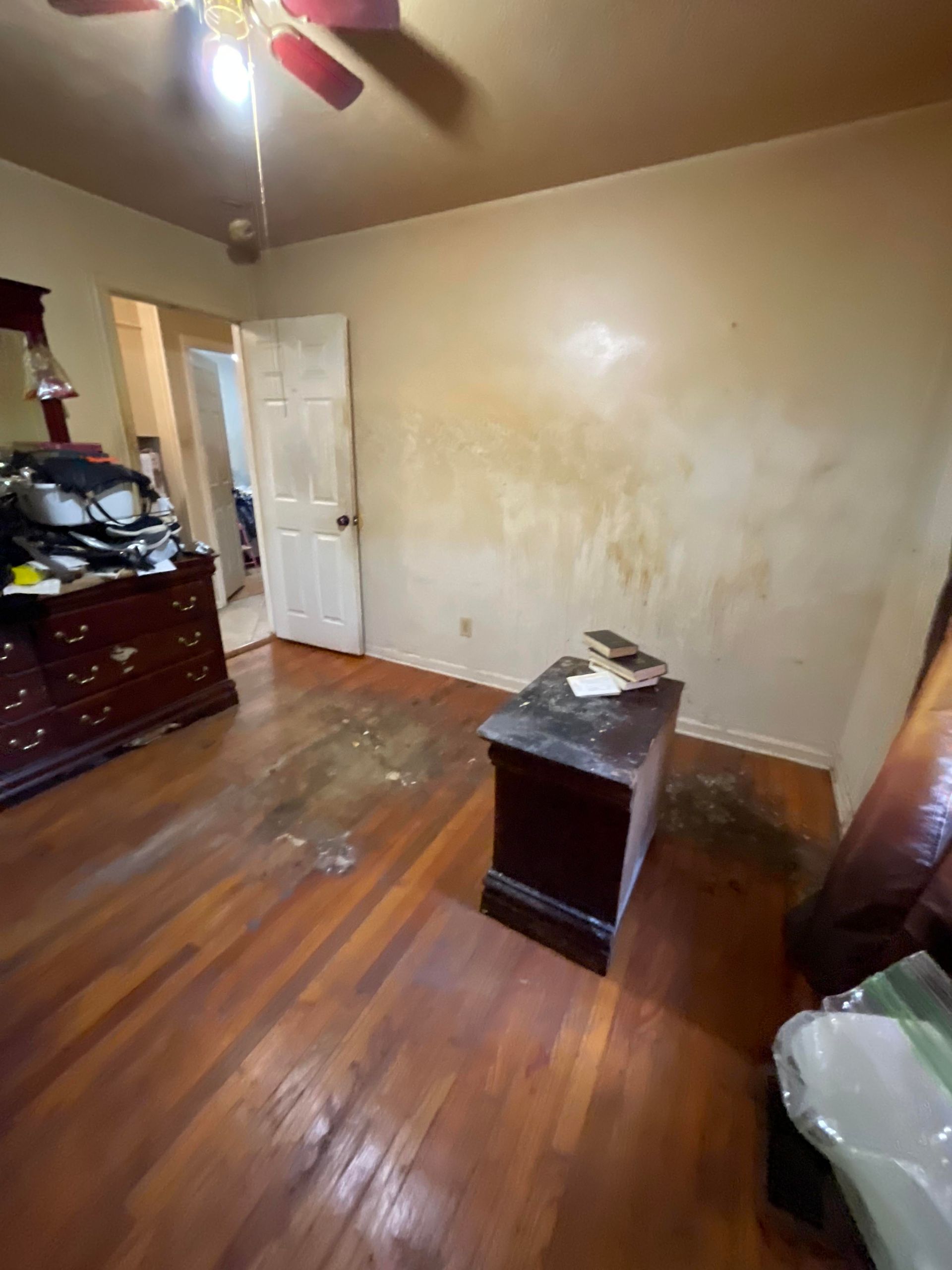 There is a ceiling fan in the room and a dresser.