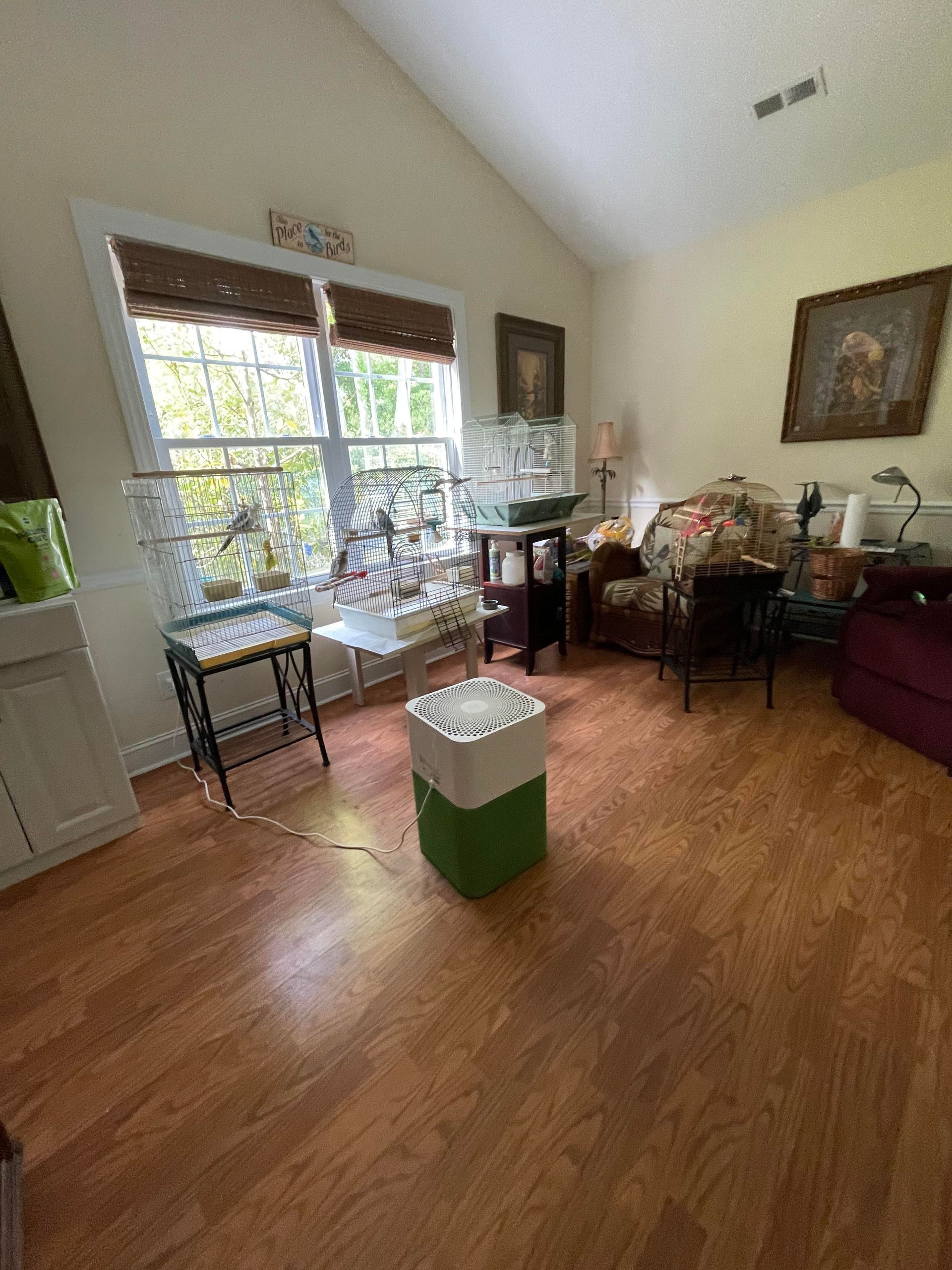 A living room filled with furniture and a green trash can.