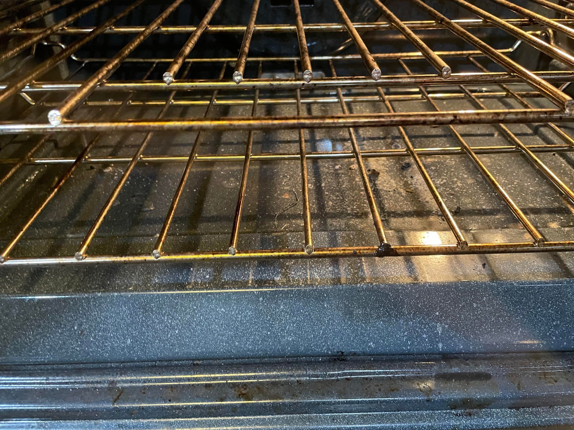 A dirty oven with a wire rack in it