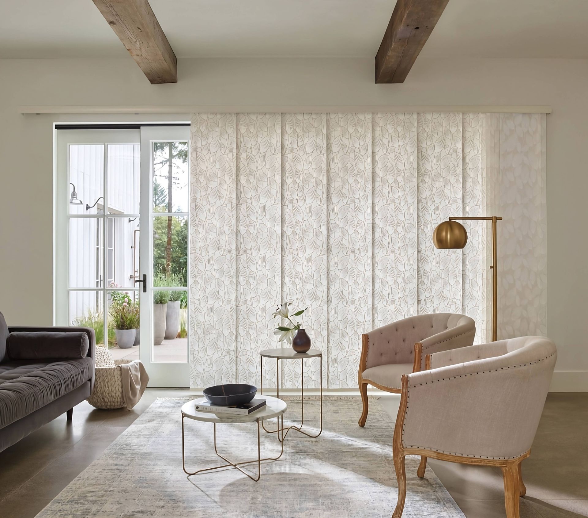 Neutral patterned Hunter Douglas Skyline® Panel-Track Blinds adorning a sliding patio door in a living room at Advantage Blinds near Prosper, Texas (TX)